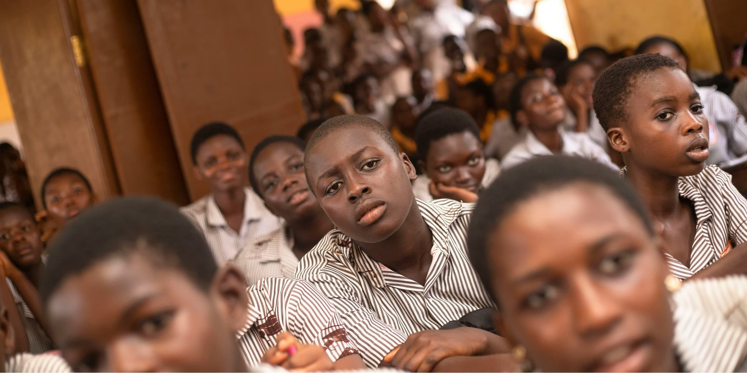 Learners in school uniform seated together in a classroom