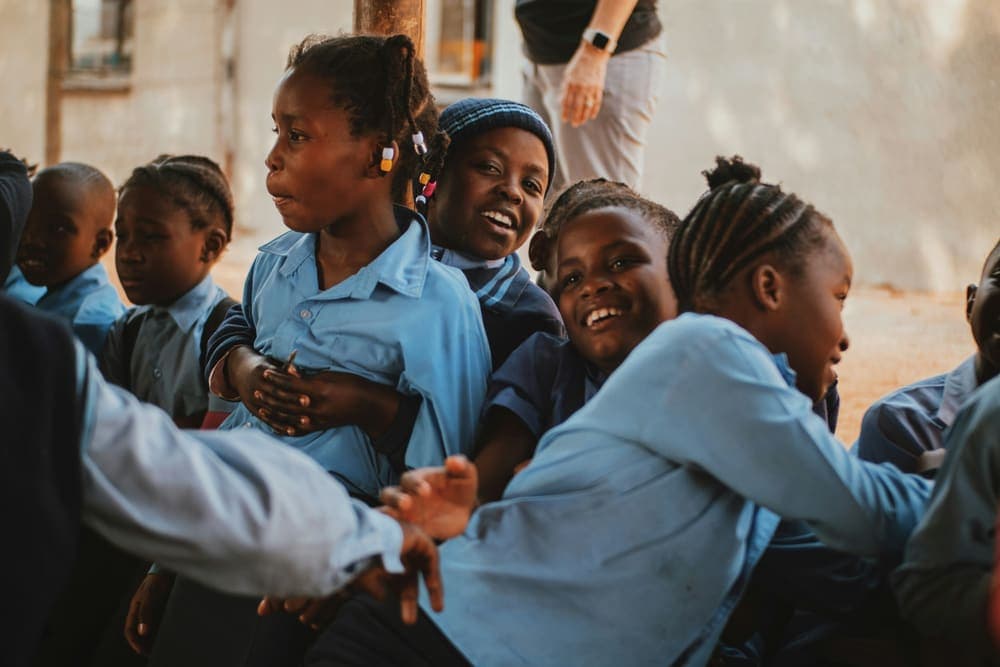 A group of learners smiling together outside their classroom